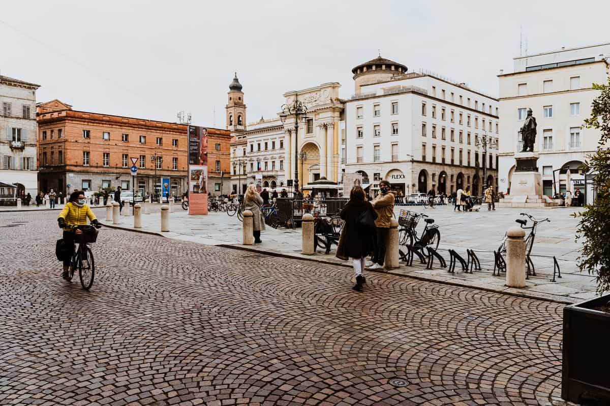 Хора, разхождащи се по тротоара в Парма, Италия